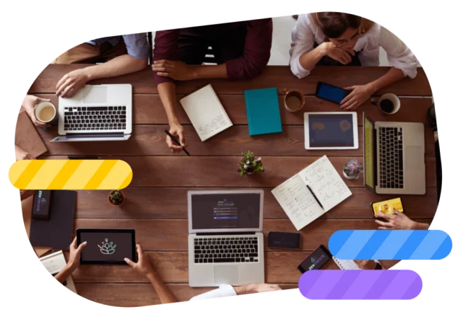 Team collaborating with laptops, tablets and smartphones in a creative space.