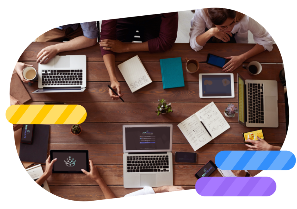 Team collaborating with laptops, tablets, and smartphones in a creative workspace.